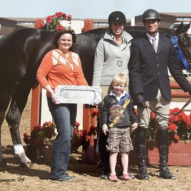 A family celebrating at a horse show with their ribbon.